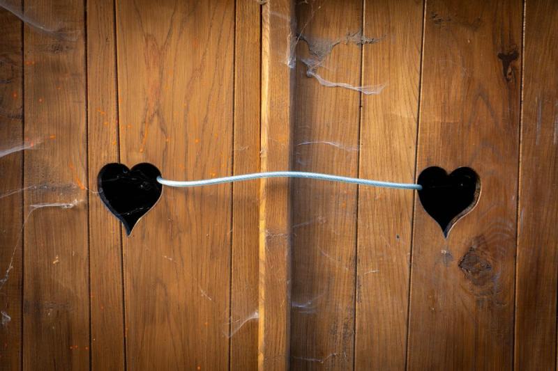 Deux coeurs en creux reliés par une ficelle sur une porte de garage.