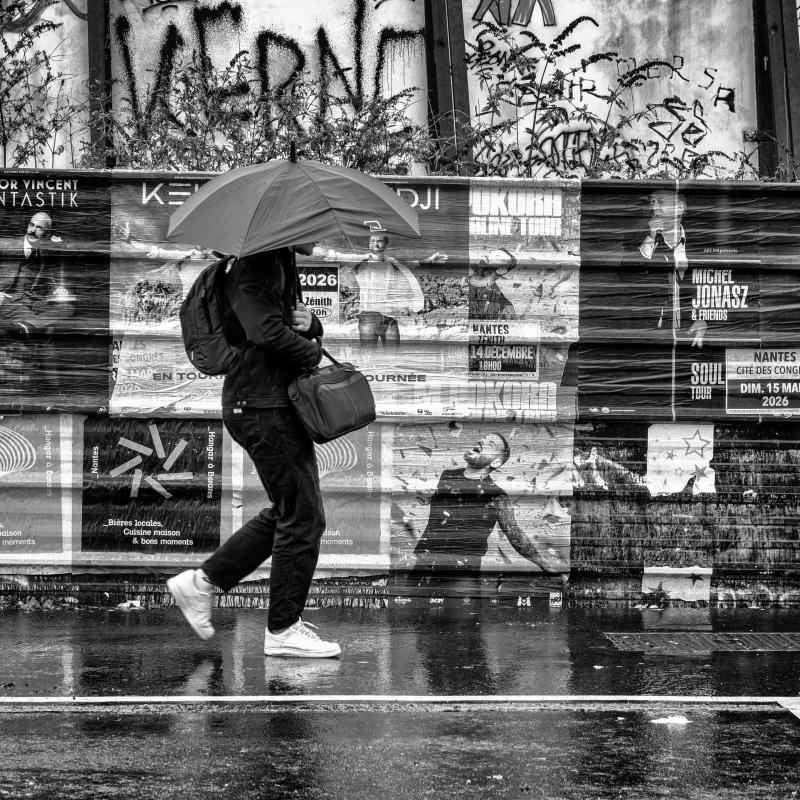 Femme au parapluie devant des affiches
