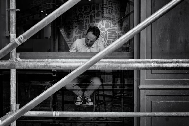 Homme au travail vu à travers des échafaudages